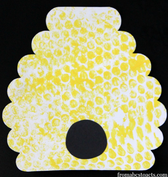 Beehive painting made with paper, construction paper, yellow paint, and bubble wrap to give the hive a honeycomb texture.